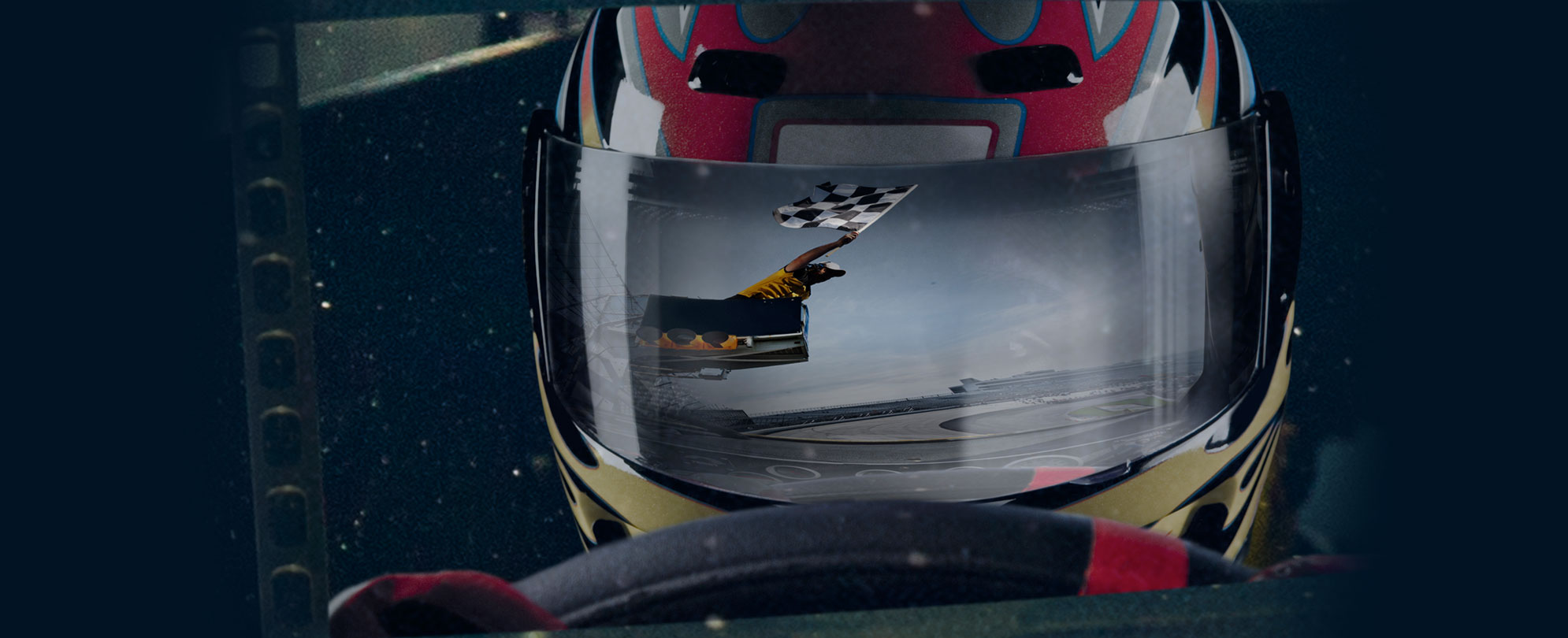 A close-up of a racecar driver with two hands on the wheel and a reflection of a grand marshall waving the checkered winner's flag. 