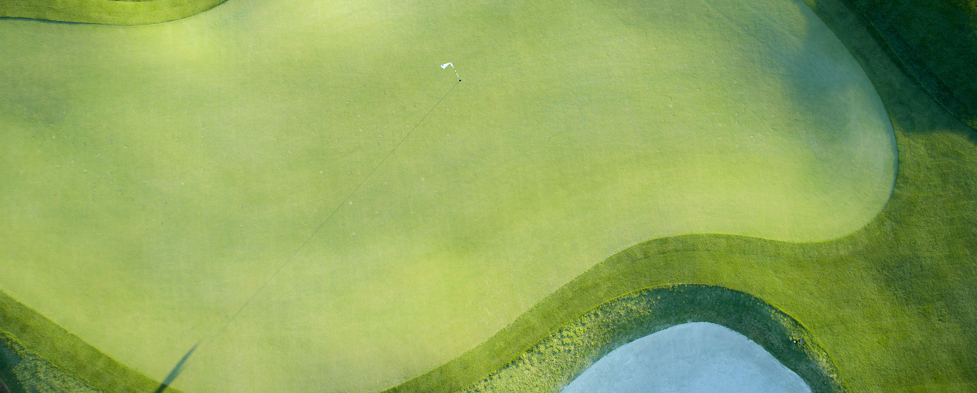 Overhead shot of a flagstick on a golf course. 